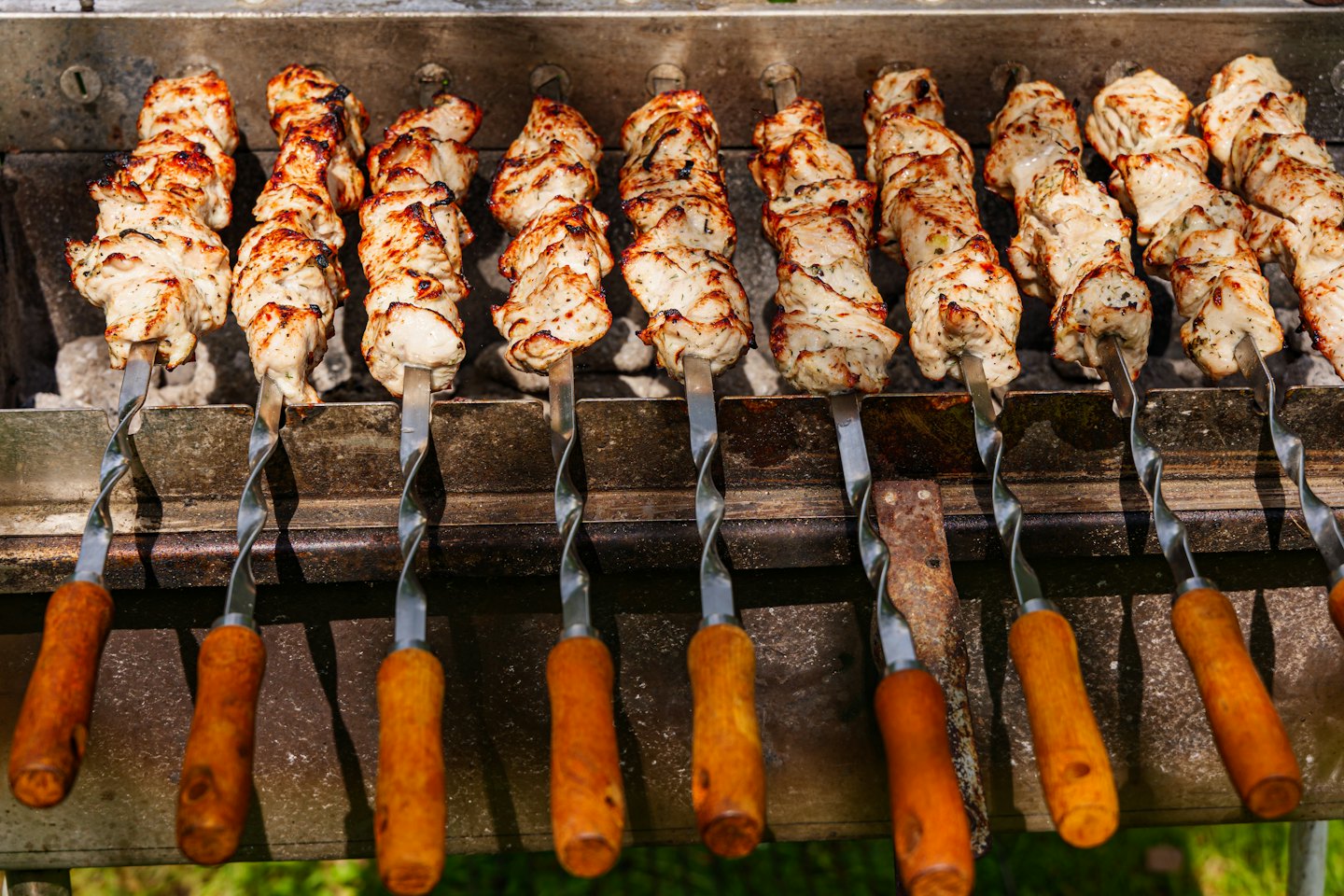 Marinated chicken skewers grilling over hot coals.